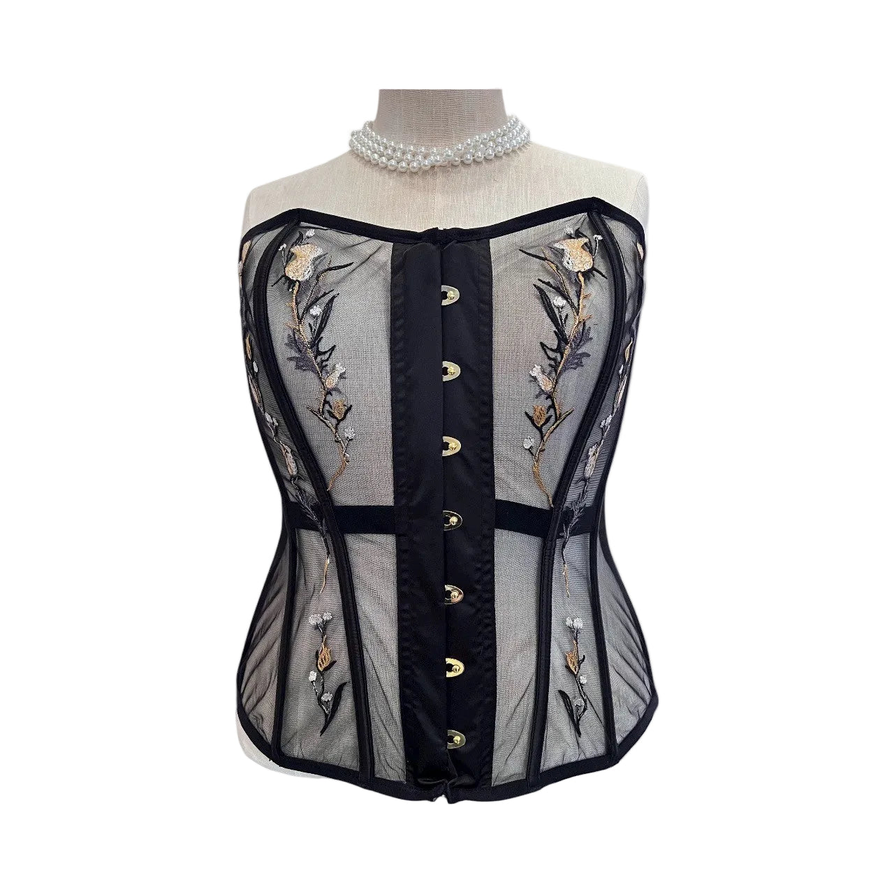 Black corset with floral embroidery on a mannequin against a white background