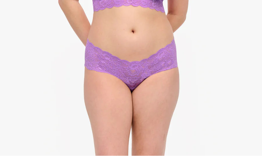Woman wearing a purple lingerie set on a white background