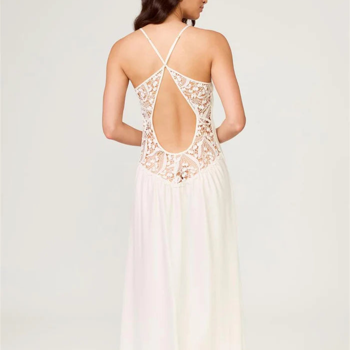 Woman wearing a white lace dress with an open back on a light gray background