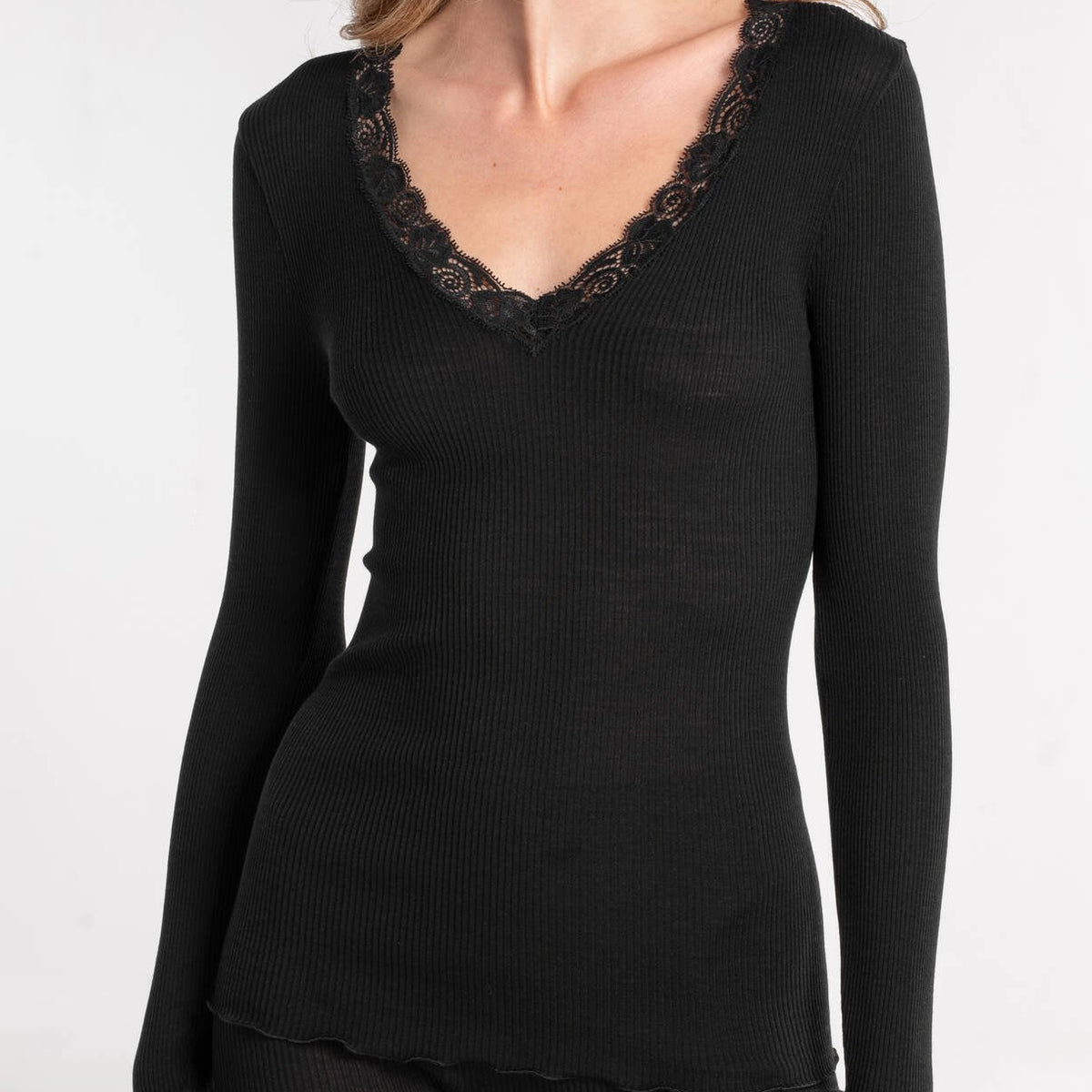 Black long-sleeve top with lace trim on a white background