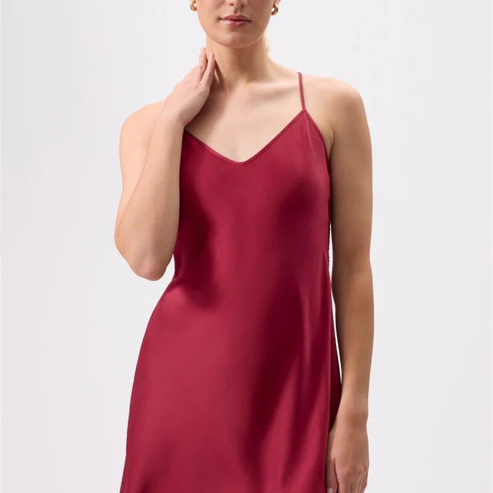 Woman wearing a red slip dress against a white background