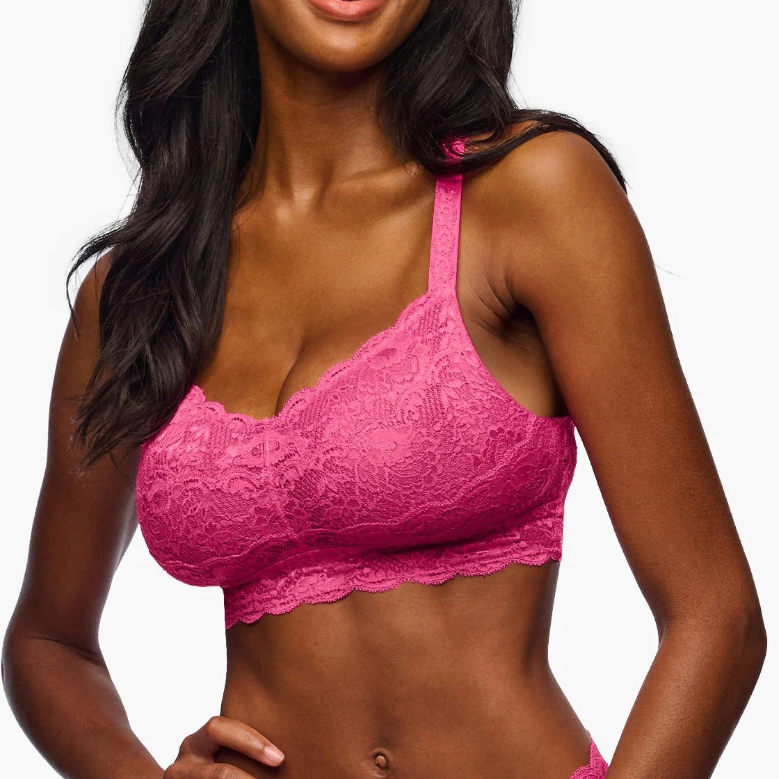 Woman wearing a pink lace lingerie set on a white background