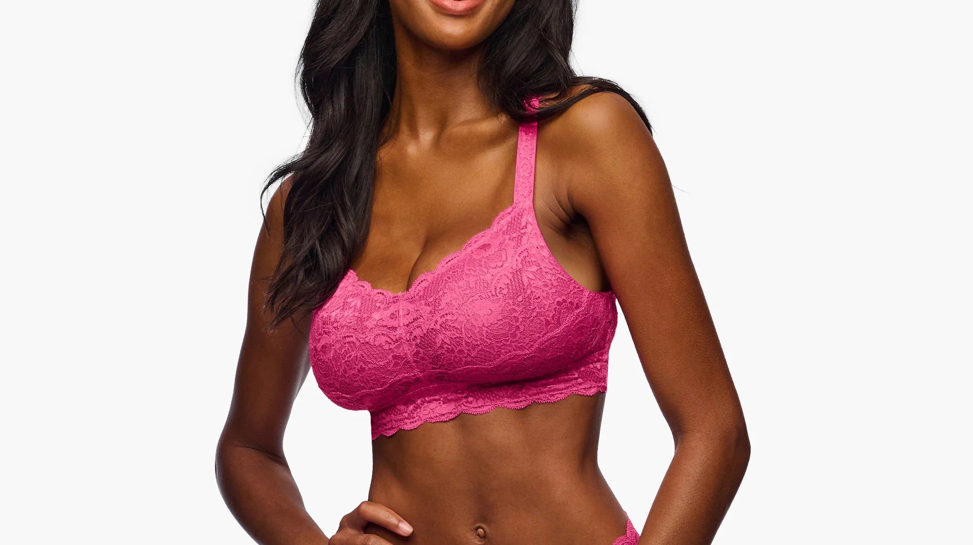 Woman wearing a pink lace lingerie set on a white background