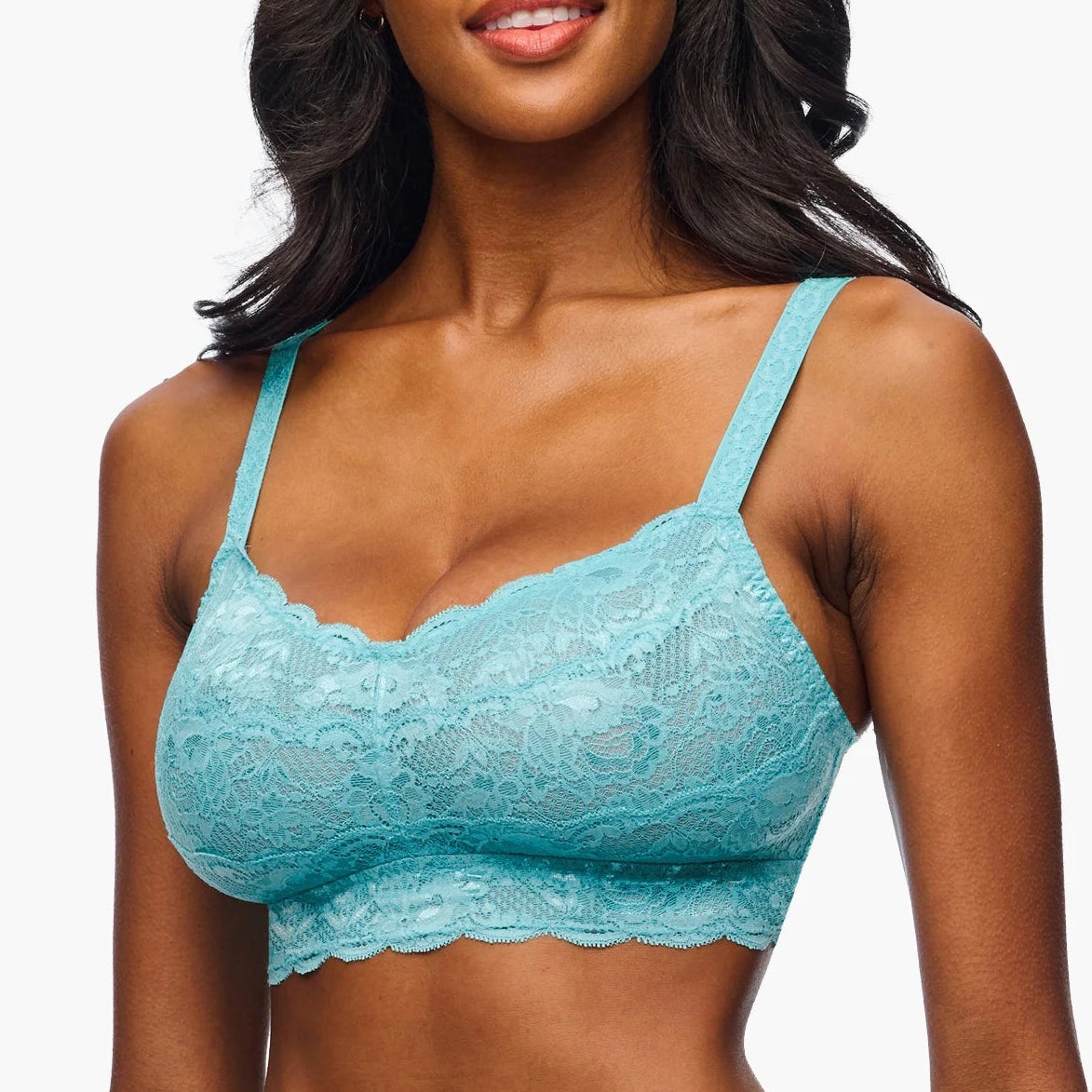 Woman wearing a turquoise lace lingerie set on a white background