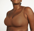 Woman wearing a brown bra against a white background