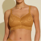 Woman wearing a mustard yellow lace bralette against a beige background