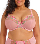 Woman wearing a pink bra with floral embroidery on a white background