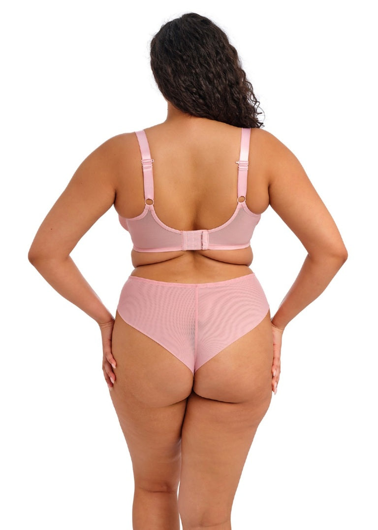 Person wearing a pink lingerie set on a white background