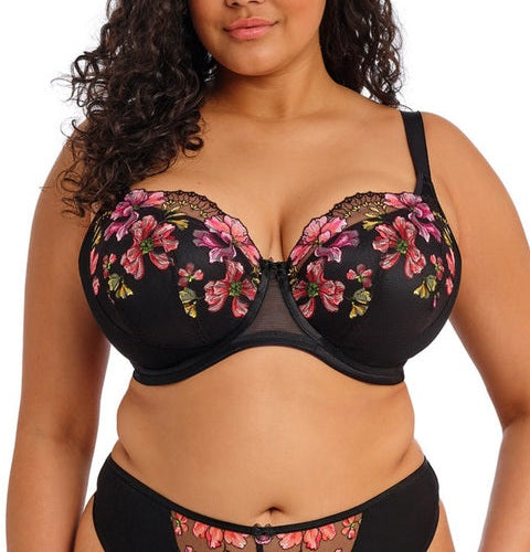 Woman wearing a black floral bra and panties set on a white background