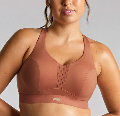 Woman wearing a brown sports bra against a gray background