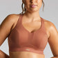 Woman wearing a brown sports bra against a gray background