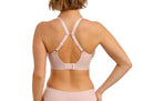 Woman wearing a light pink lingerie set on a white background