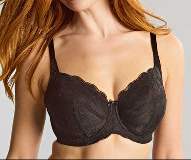 Woman wearing a black bra against a plain background