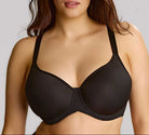 Woman wearing a black bra against a plain background