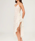 Woman wearing a white lace dress with a high slit on a light gray background