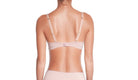 Woman wearing a sheer beige lingerie set on a white background