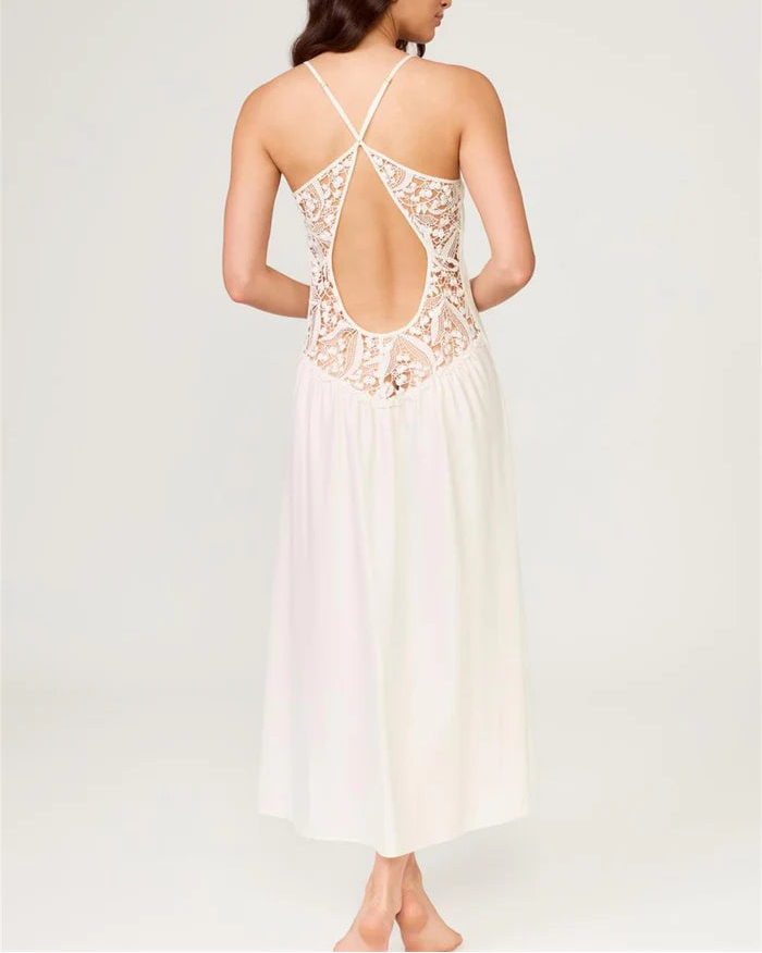 Woman wearing a white lace dress with an open back on a light gray background