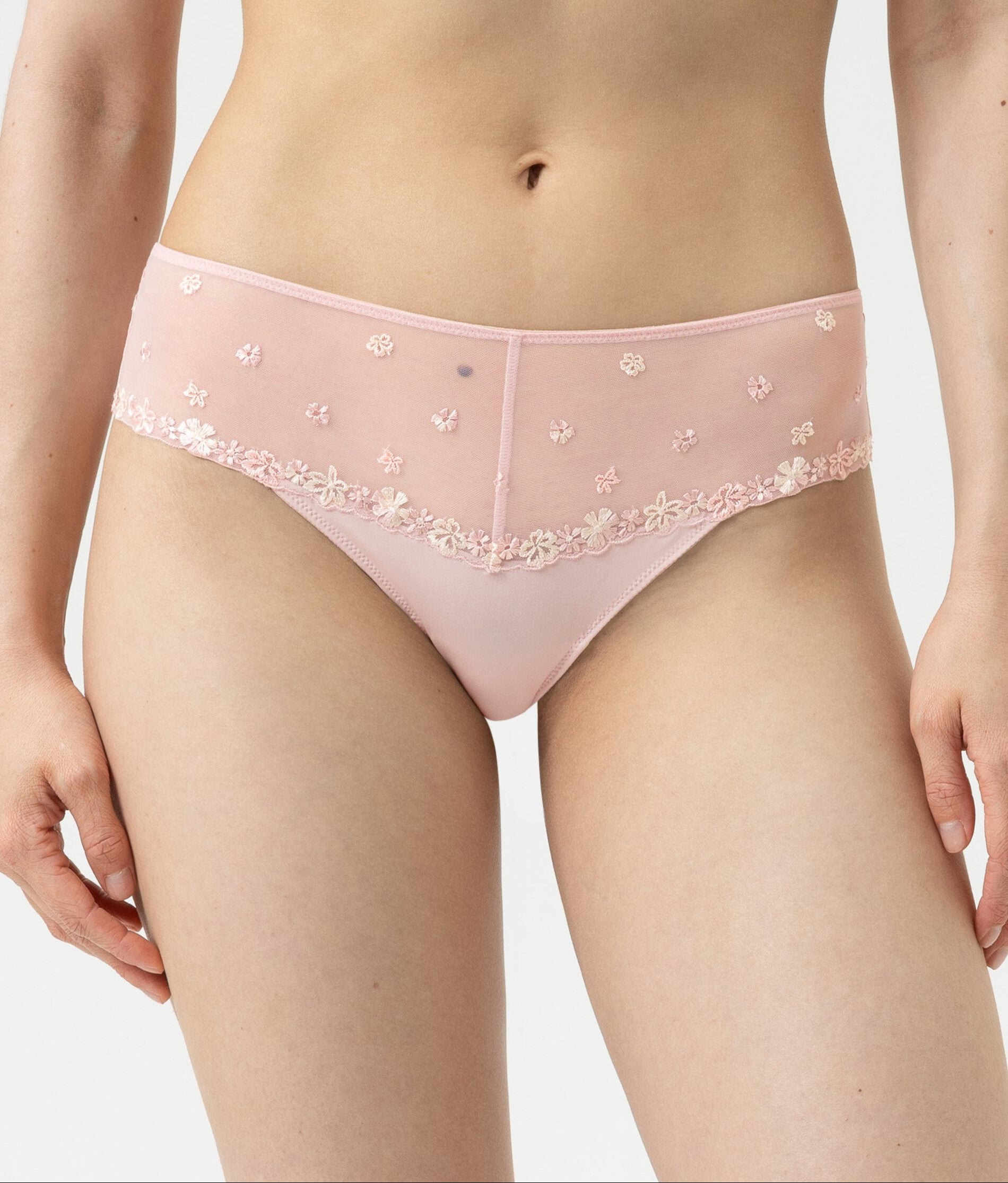 Person wearing a pink bra and panties set on a plain background