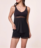 Woman wearing a black tank top and shorts set on a beige background