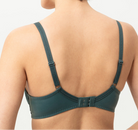 Woman wearing a green bra against a plain background