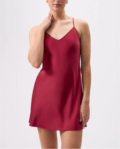 Woman wearing a red slip dress against a white background