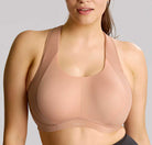 Woman wearing a beige sports bra against a gray background