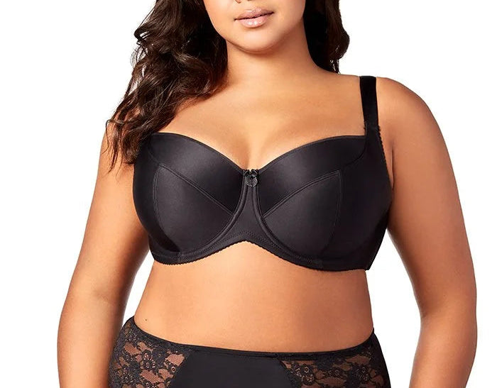 Woman wearing a black bra and lace underwear set on a white background