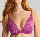 Woman wearing a purple lace bra against a plain background