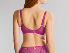 Woman wearing a purple lingerie set on a gray background
