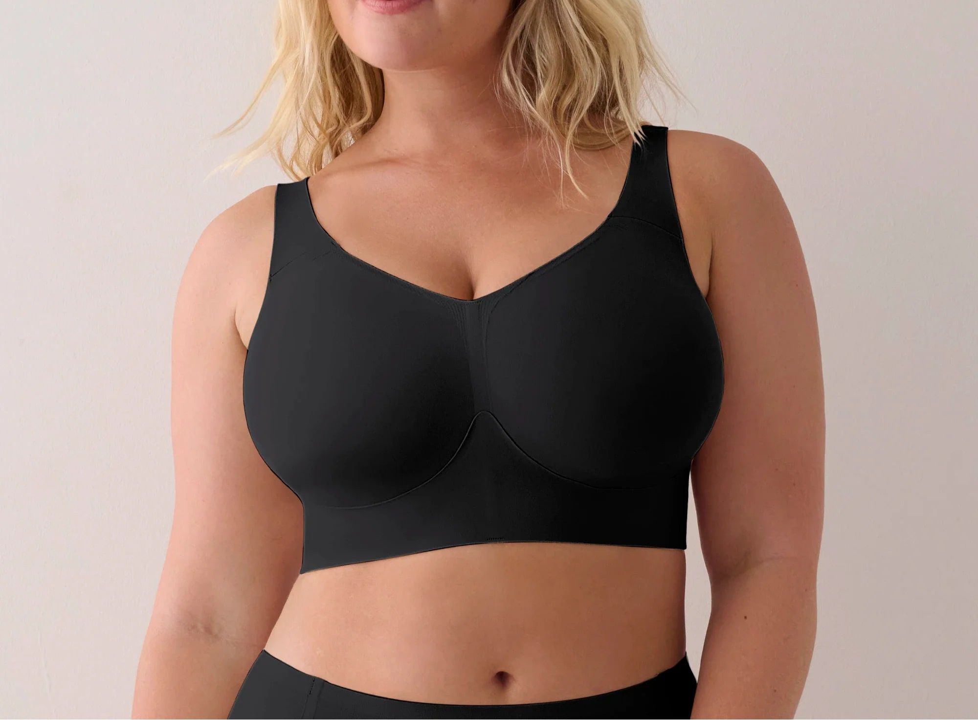 Woman wearing a black sports bra against a plain background