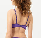 Woman wearing a purple lingerie set on a white background