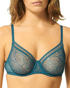 This image displays the Comete Full Cup Bra by Simone Perele, modeled in a sophisticated and stylish manner. The bra features a rich, dark green lace fabric, providing an elegant appearance while offering a comfortable fit.
