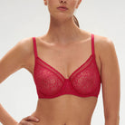This image displays the Comete Full Cup Bra by Simone Perele, modeled in a sophisticated and stylish manner. The bra features a rich, dark green lace fabric, providing an elegant appearance while offering a comfortable fit.