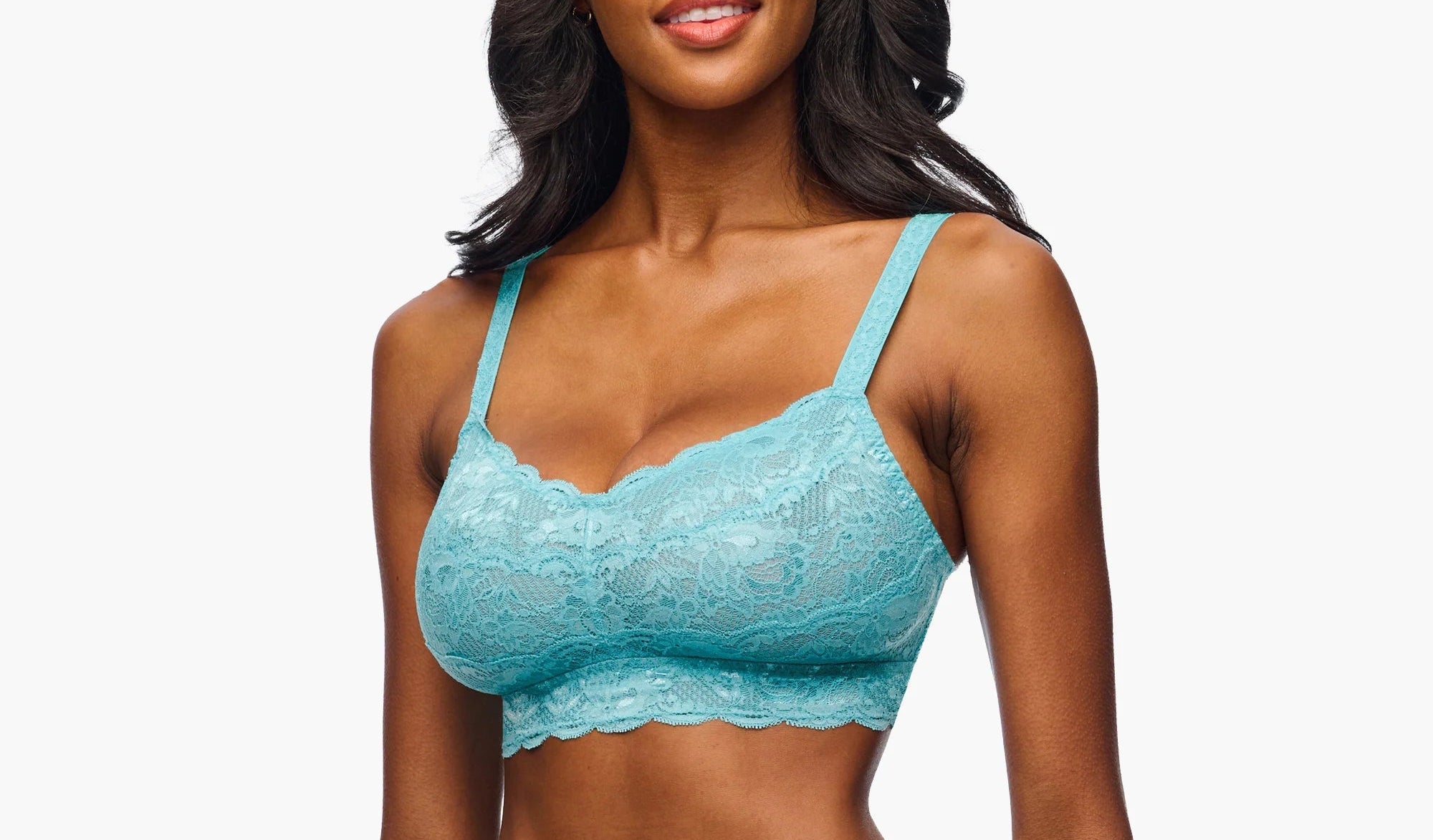 Woman wearing a turquoise lace lingerie set on a white background