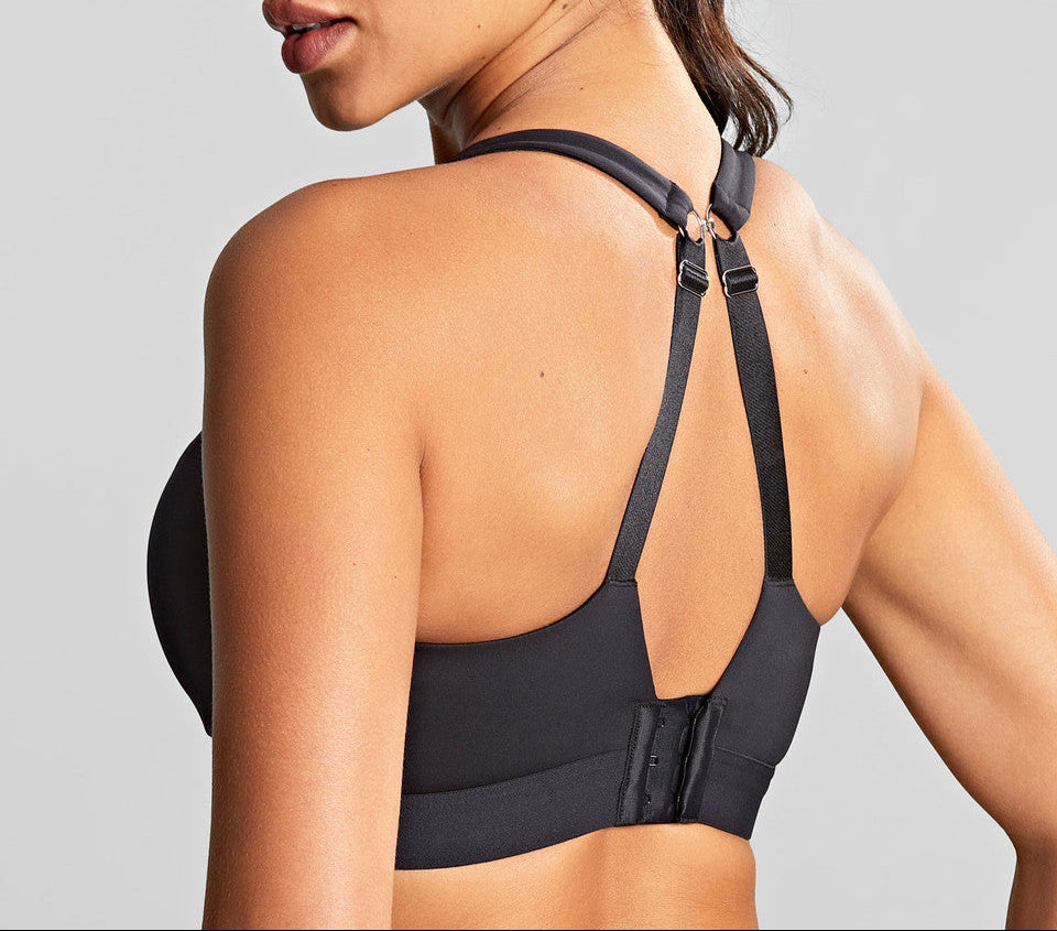 Woman wearing a black sports bra against a gray background