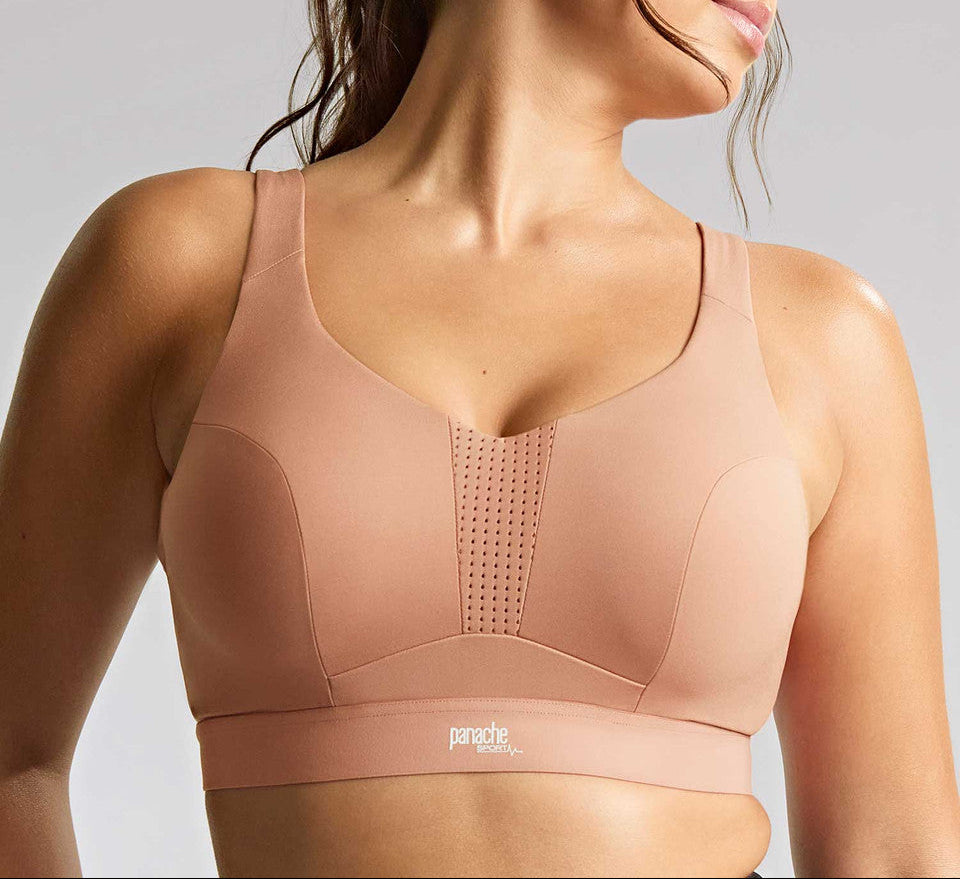 Woman wearing a beige sports bra with a gray background