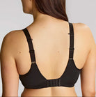 Woman wearing a black bra against a plain background