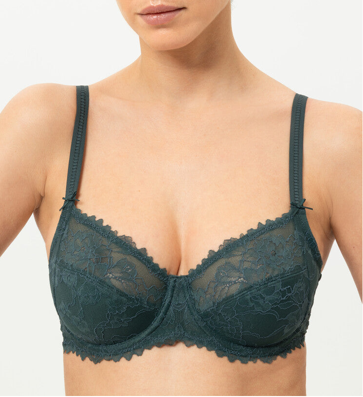 Woman wearing a dark green lace bra against a white background