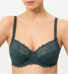 Woman wearing a dark green lace bra against a white background