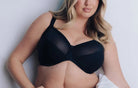 Woman wearing a black bra and panties set against a white background